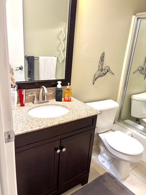 bathroom with toilet, tile patterned flooring, and vanity