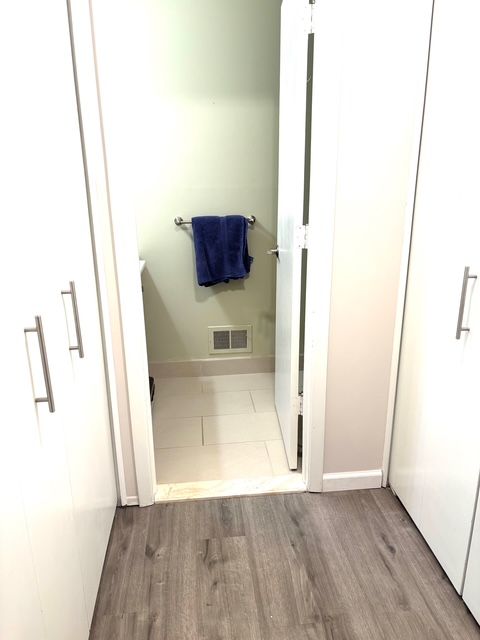 bathroom with wood finished floors, visible vents, and baseboards
