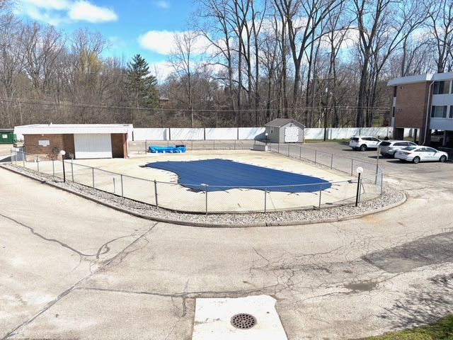 view of swimming pool featuring an outbuilding, a fenced in pool, and fence