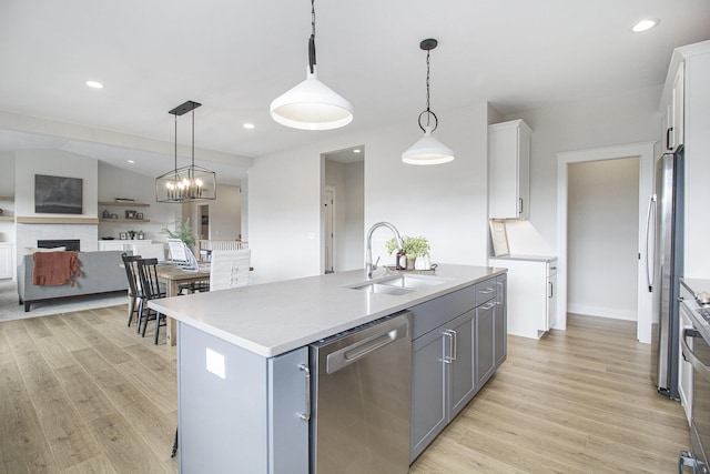 kitchen with light wood-type flooring, a sink, stainless steel appliances, and gray cabinets