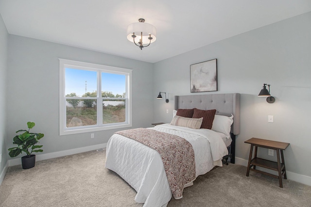 carpeted bedroom with baseboards and a notable chandelier
