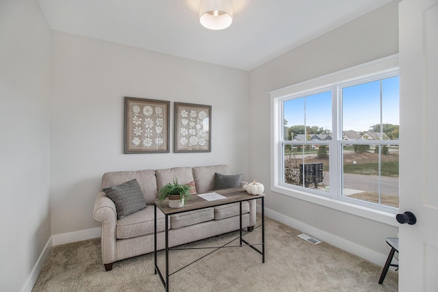 living room featuring baseboards, visible vents, and light colored carpet