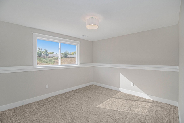 carpeted spare room featuring visible vents and baseboards