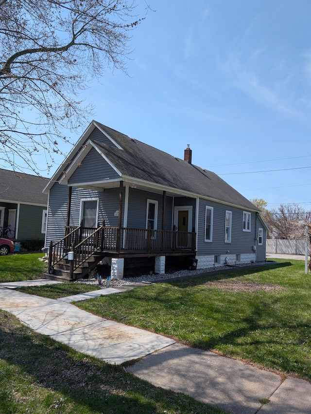 view of front of home featuring fence, a front yard, a chimney, and a porch