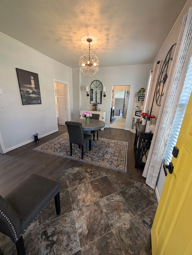 dining space with baseboards and a notable chandelier