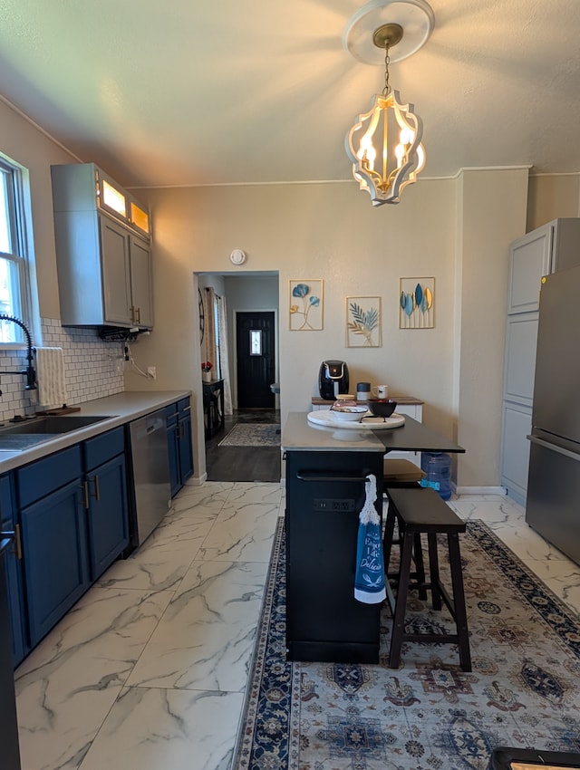 1204 Stanton St, Bay City, MI 48708 - kitchen featuring stainless steel appliances, a chandelier, light marble finish floors, and a sink