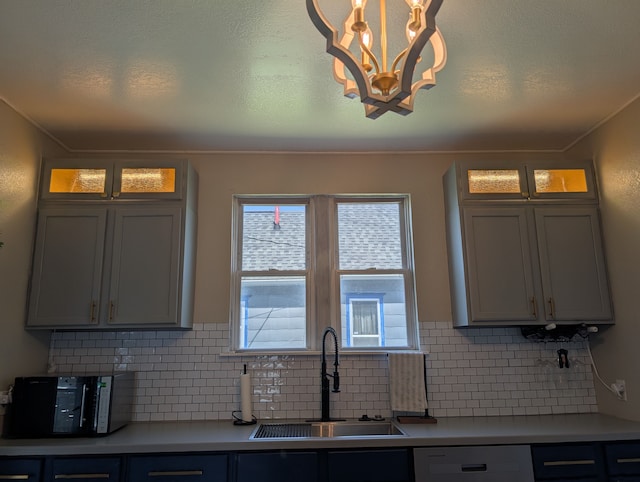 kitchen featuring ornamental molding, dishwasher, light countertops, and a sink
