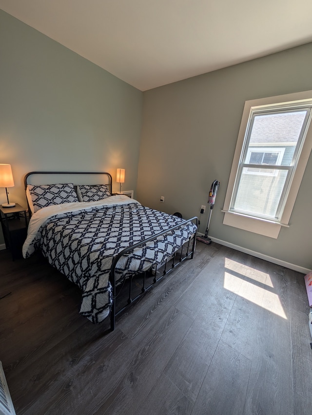 bedroom featuring dark wood-style floors and baseboards