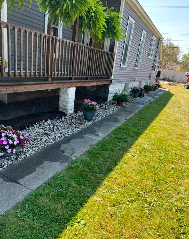 view of home's exterior featuring fence and a lawn