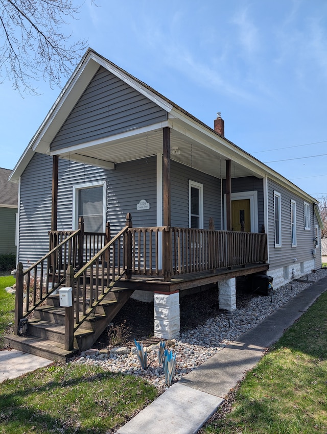 1204 Stanton St, Bay City, MI 48708 - view of front of house with covered porch and a chimney