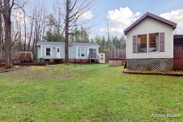back of property with a yard and a wooden deck