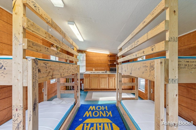 bedroom with a textured ceiling and wood walls