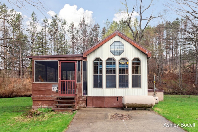 mediterranean / spanish-style home with a sunroom and a front lawn