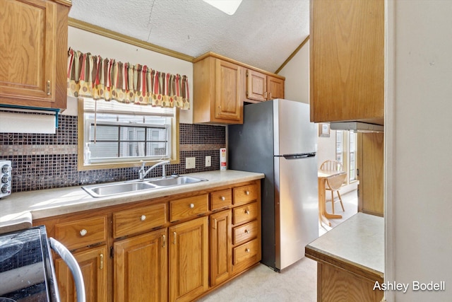 kitchen with light colored carpet, freestanding refrigerator, light countertops, backsplash, and a sink