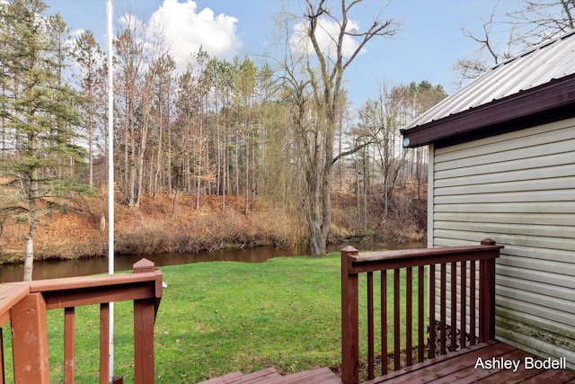 view of yard with a deck with water view