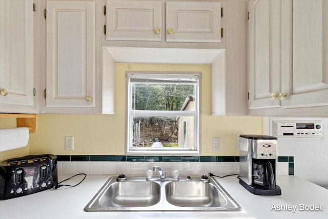 interior details featuring white cabinetry, light countertops, and a sink