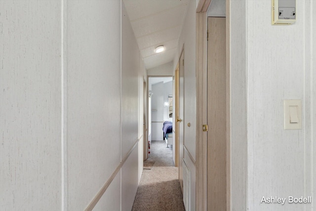 corridor featuring carpet and vaulted ceiling