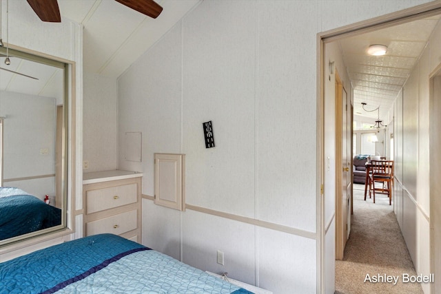 bedroom with ceiling fan, vaulted ceiling, and carpet floors