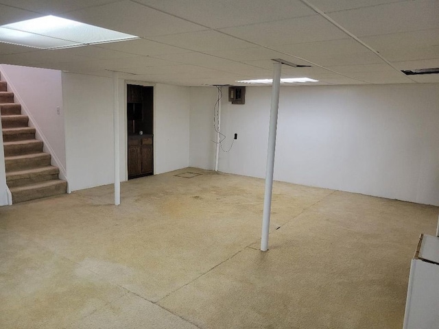 finished basement featuring a drop ceiling, carpet flooring, and stairs