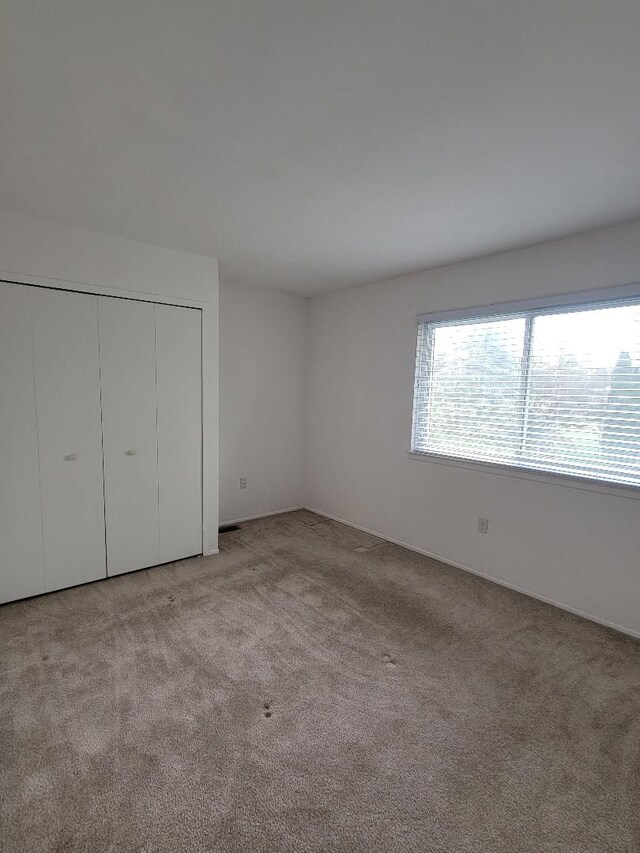 unfurnished bedroom featuring a closet and carpet flooring
