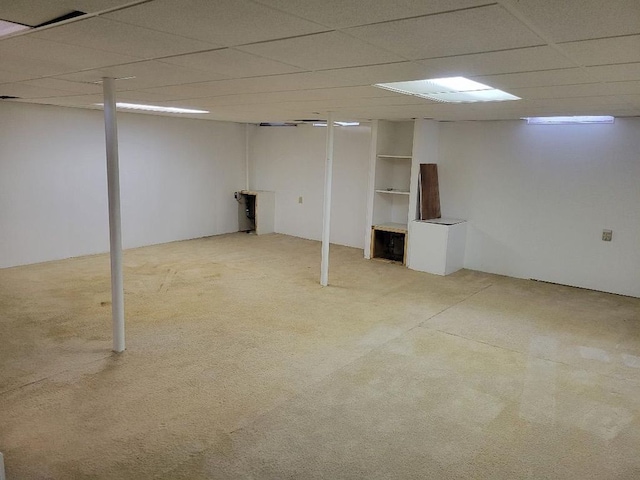 finished below grade area with a drop ceiling and light colored carpet