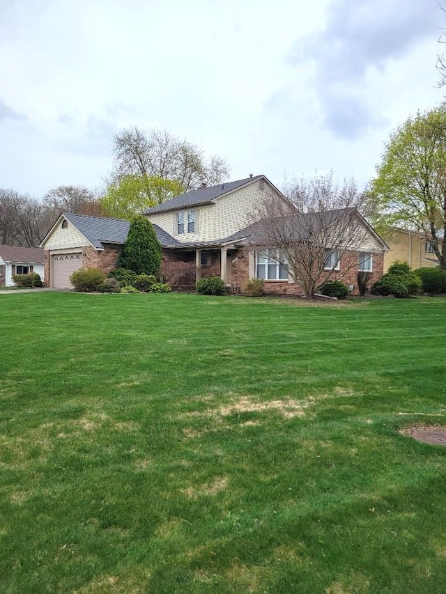 view of front of property featuring brick siding, a front lawn, and an attached garage
