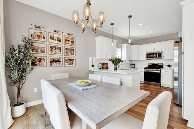 dining area with recessed lighting, a notable chandelier, baseboards, and wood finished floors