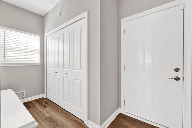 interior space featuring baseboards and dark wood-style floors