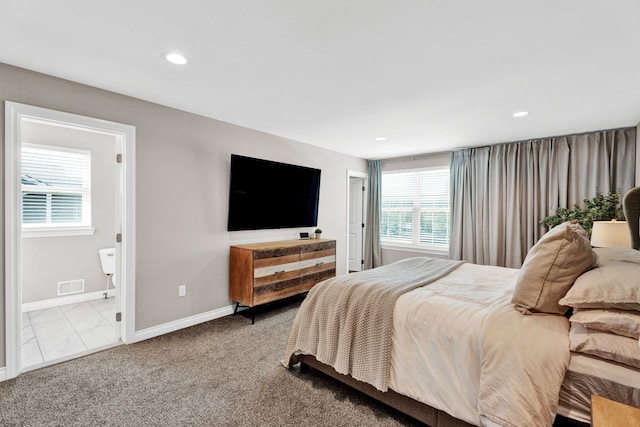 bedroom featuring baseboards, recessed lighting, ensuite bath, and visible vents
