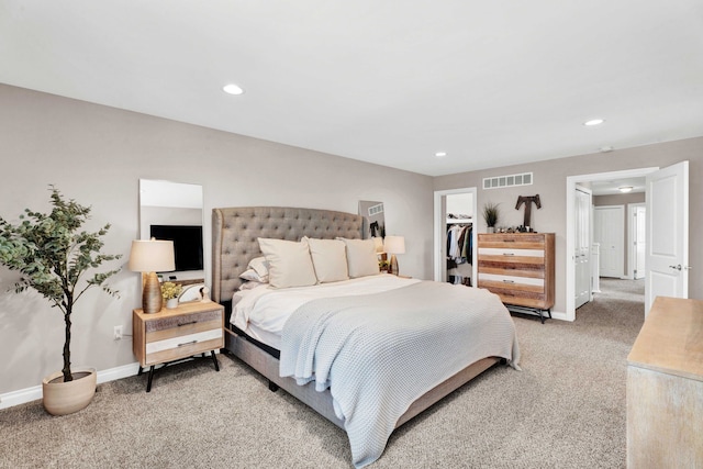 bedroom featuring visible vents, baseboards, a spacious closet, and light carpet