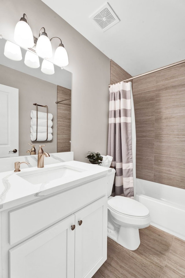 bathroom featuring toilet, visible vents, vanity, and shower / tub combo with curtain