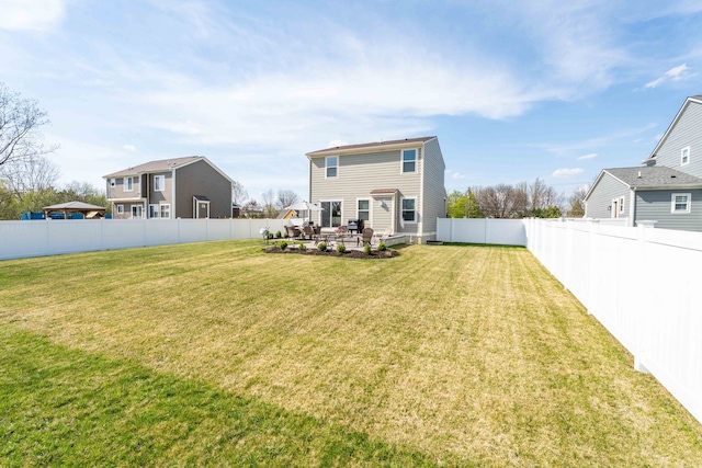 rear view of property featuring a lawn, a patio, and a fenced backyard