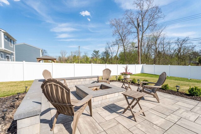 view of patio featuring an outdoor fire pit and a fenced backyard