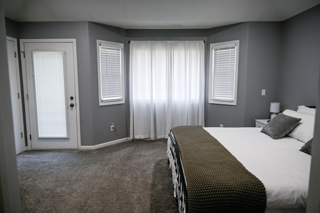bedroom featuring dark carpet and baseboards