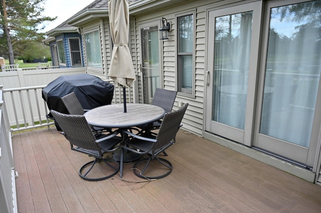 wooden terrace featuring a grill and outdoor dining area