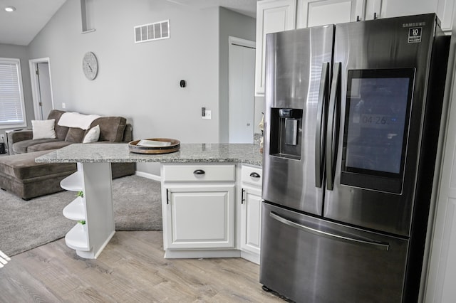 kitchen with stainless steel fridge, light wood-type flooring, visible vents, white cabinetry, and a peninsula