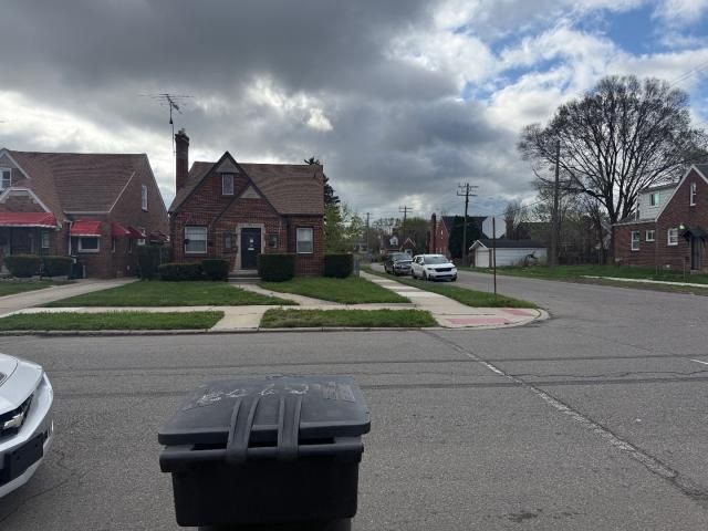 view of street featuring traffic signs, a residential view, sidewalks, and curbs