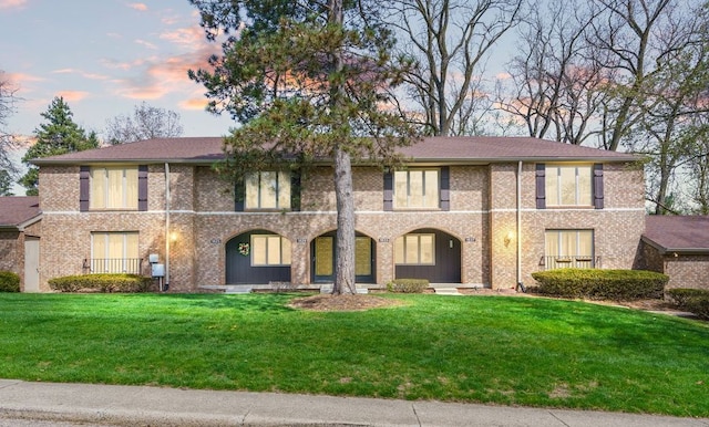 view of front of home featuring a front yard and brick siding