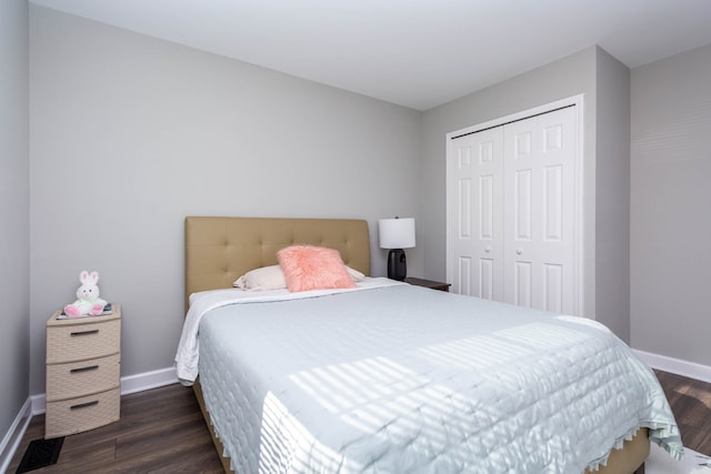 bedroom featuring baseboards, dark wood-style floors, and a closet