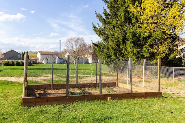 view of yard with fence, a garden, and a residential view