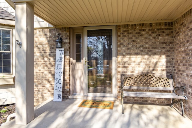 entrance to property featuring brick siding