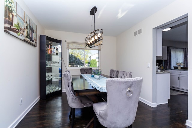 dining room with visible vents, dark wood-style flooring, and baseboards