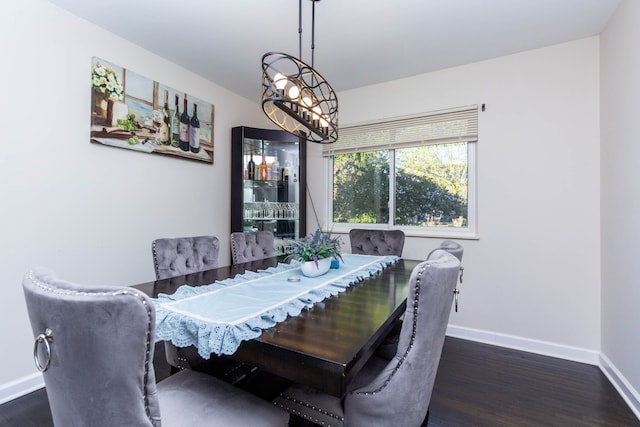 dining space with baseboards and wood finished floors