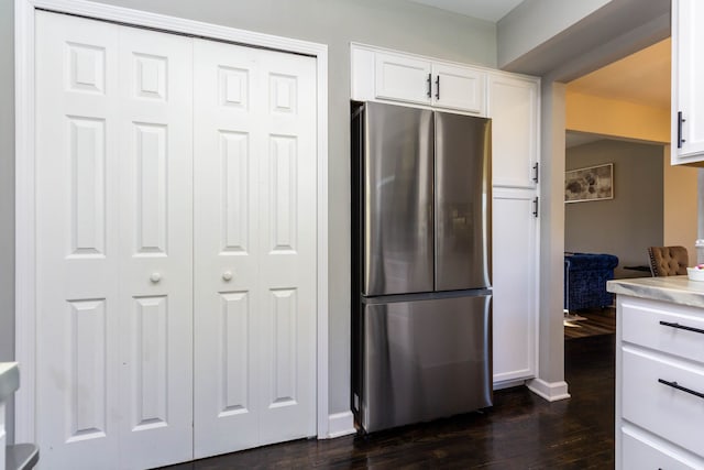kitchen featuring light countertops, baseboards, white cabinets, freestanding refrigerator, and dark wood-type flooring