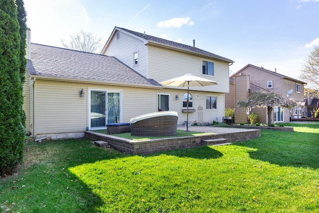rear view of house featuring a lawn and a shingled roof