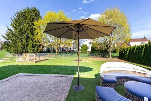view of yard featuring a patio area, fence, and a vegetable garden