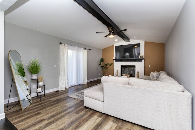 living room with wood finished floors, a fireplace, baseboards, ceiling fan, and lofted ceiling with beams