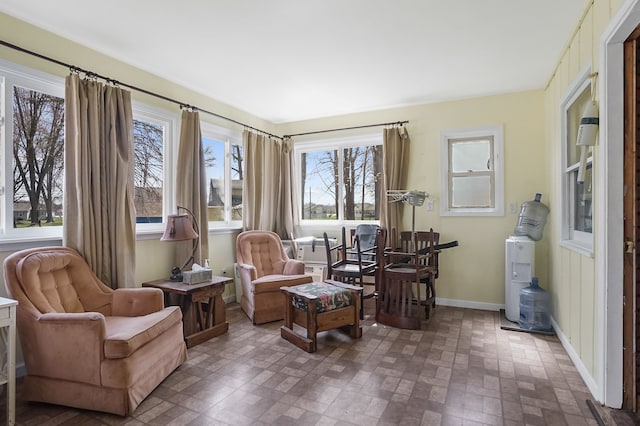 sitting room with baseboards and brick patterned floor