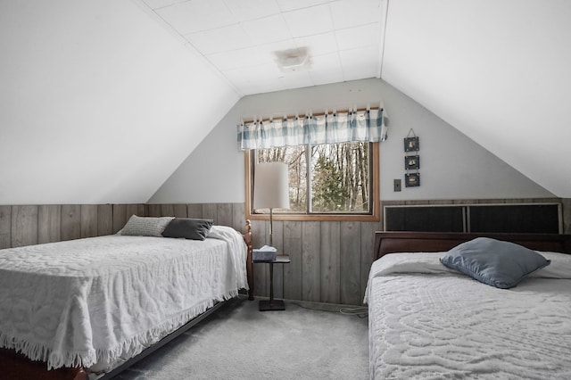 carpeted bedroom with wood walls, lofted ceiling, and a wainscoted wall