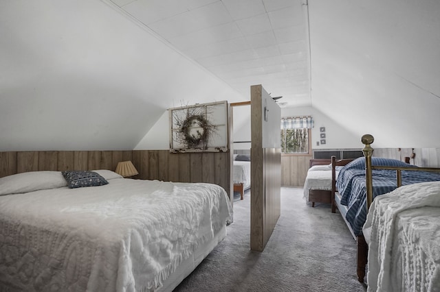 carpeted bedroom with wood walls, a wainscoted wall, and vaulted ceiling